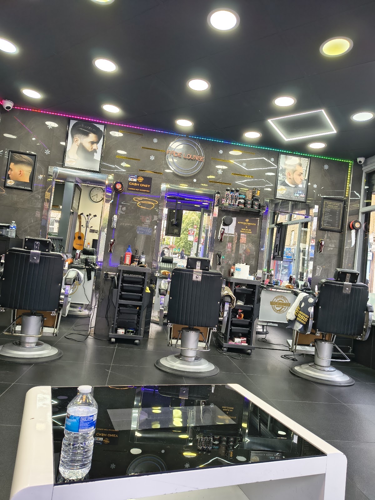 View down the length of the barbershop with empty chairs and the reception desk in the foreground