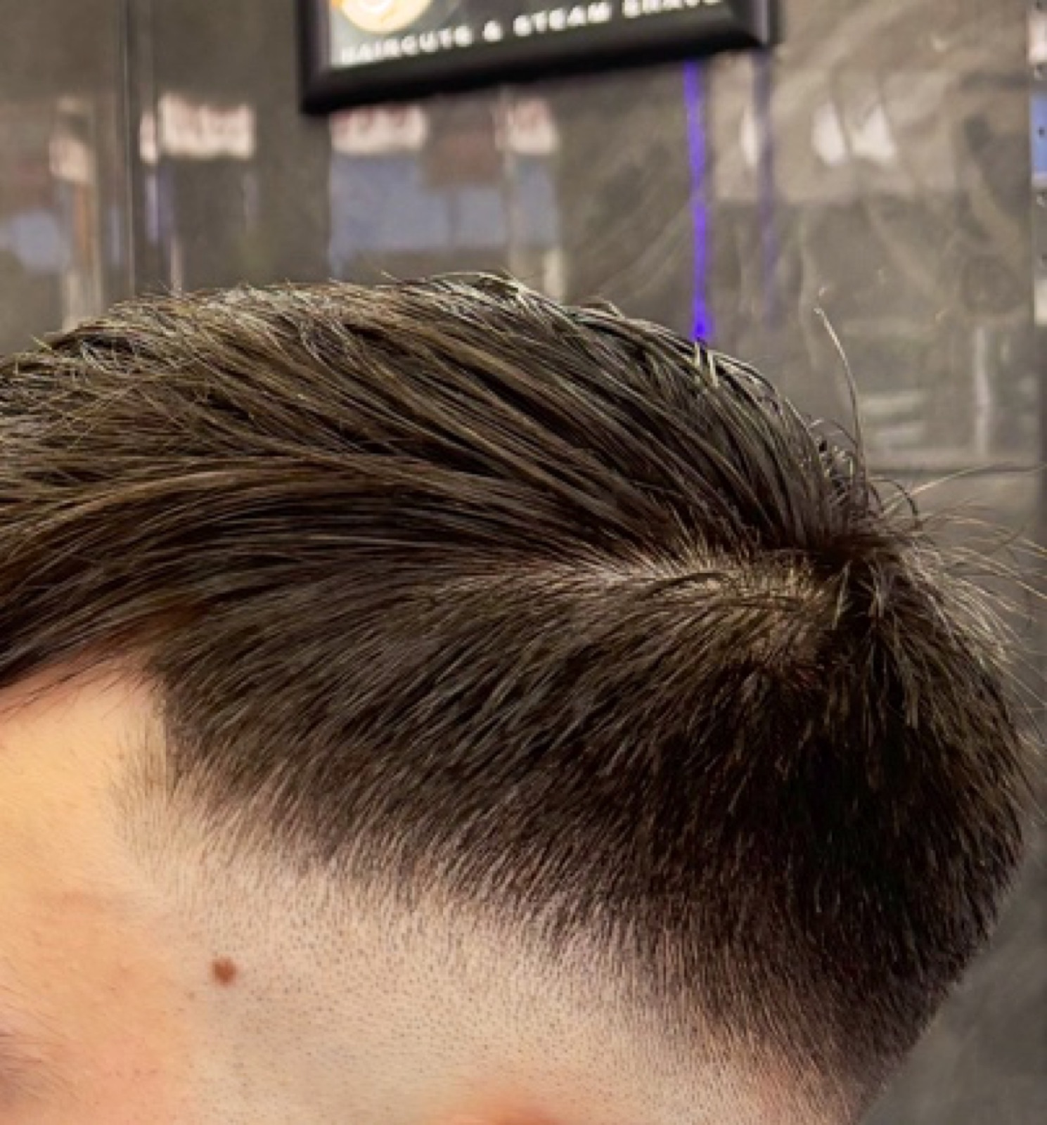 Close top-down view of a finished textured quiff with a fade at the side